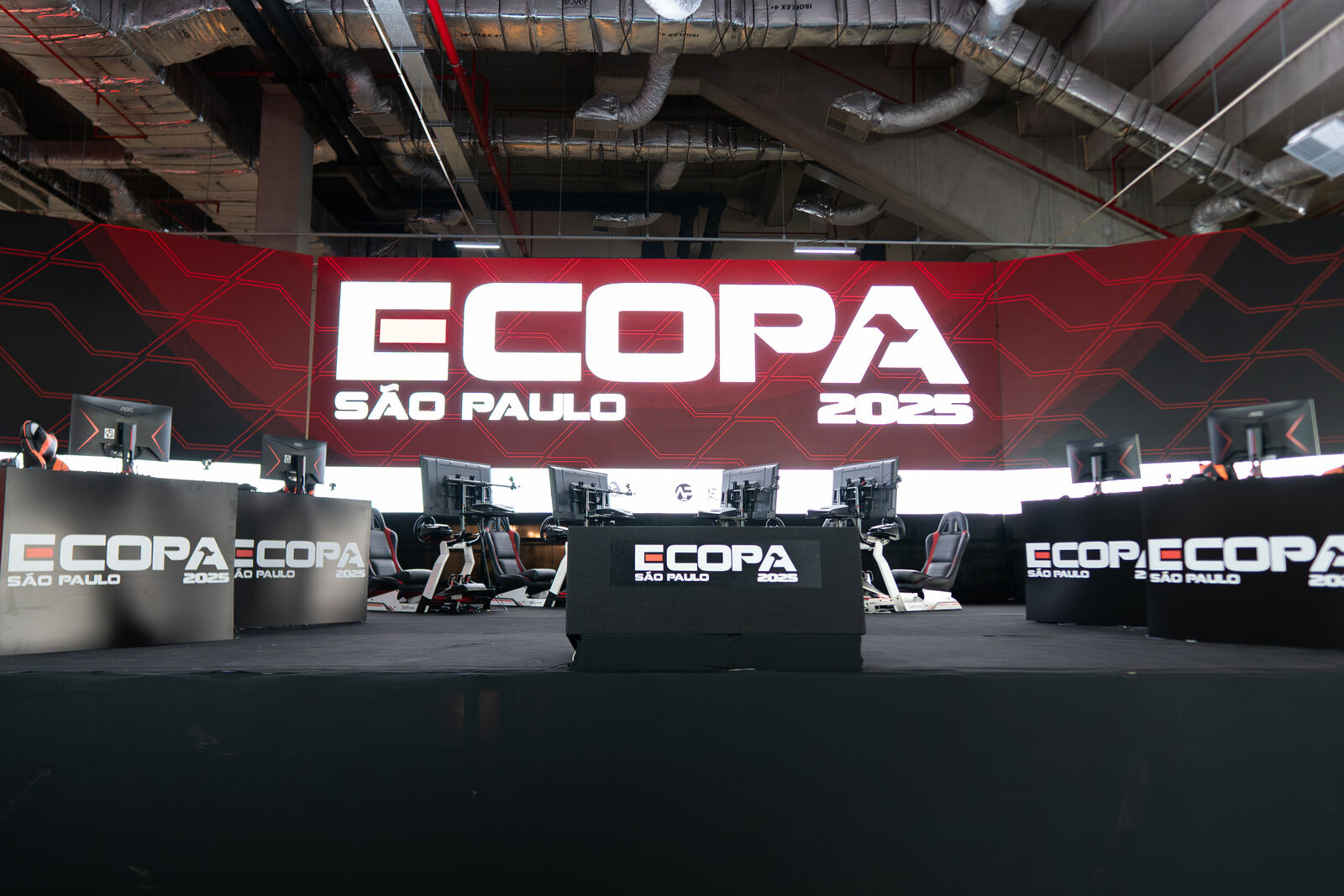 Palco da grande final da E-COPA São Paulo 2025 na Mercado Livre Arena Pacaembu com simuladores de corrida e painel LED gigante